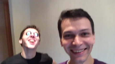 Two friends fooling around on camera with round stones in their eyes.  Stock Footage 234856151