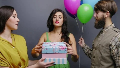 Two friends give present to happy woman Stock Footage 81750414