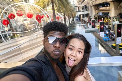 Two friends grimacing to the camera of a mobile while taking a selfie otuddors Stock Photos
