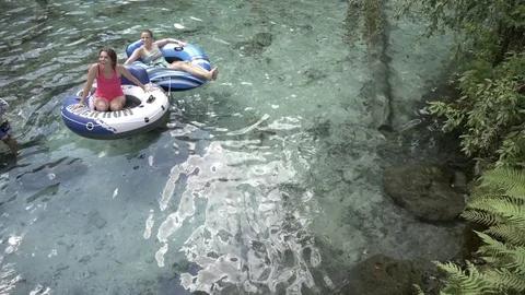 Two Friends Hang Out in Tubes at Ginnie Springs Florida Stock Footage