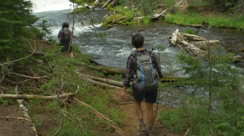 Two friends hike along a river Stock Footage 58799760