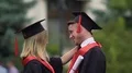 Two friends hugging at graduation ceremony, young people celebrating achievement HD Footage