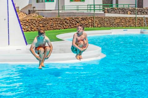 Two  friends jumping in the pool Stock Photos