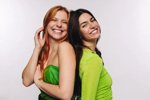 Two friends laughing back to back Stock Photos