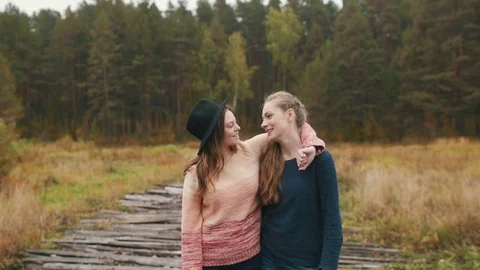 Two friends look at each other and hug. Autumn forest 스톡 동영상 69746086