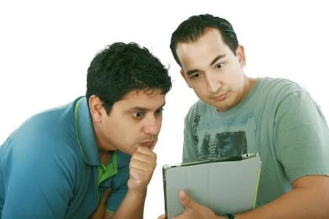 Two friends looking surprised at tablet computer against a white background Stock Photos