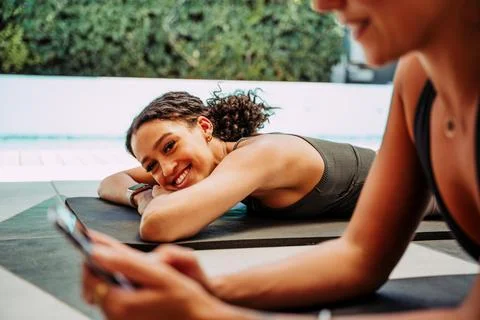 Two friends lying down outside relaxing after long workout smiling Stock Photos