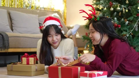 Two friends lying on the floor, surrounded by wrapped Christmas gifts and h.. Stock Footage 290191386