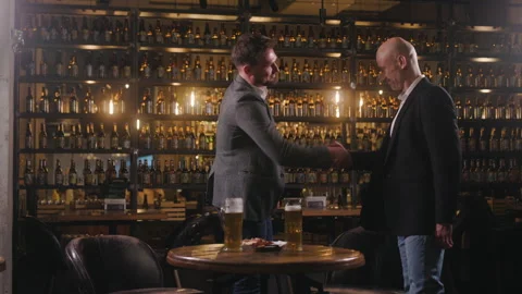 Two friends meet at a bar. The table where two mugs of beer and a plate of Stock Footage 284088619