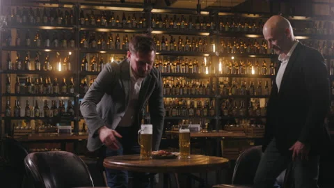 Two friends meet in a pub after work. The men, dressed in jackets and shirts Stock-Footage 237600279