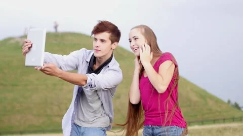 Two friends with mobile phone taking selfies.  Slow motion Stock-Footage 54591234