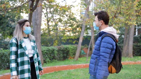 Two friends in the park high-five with no touch instead of touching elbows Stock Footage 144441249