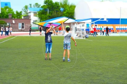 Two friends playing with kite Stock Photos