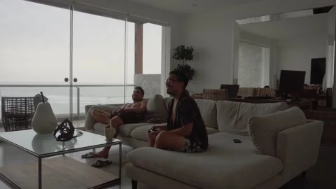 Two friends playing video games and one losing and lamenting holding his head in Stock Footage 186201026