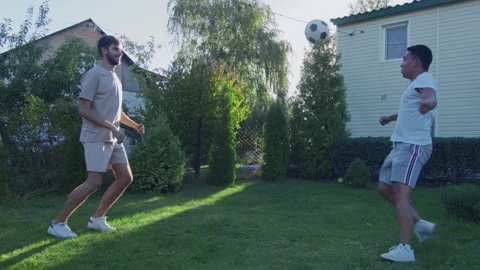 Two friends plays with ball on backyard at summer time Video stock 143491168