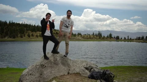 Two friends posing for a photo on a rock with the Radian lagoon in the Видео 164598937