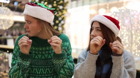 Two friends pretending to spy while choosing Christmas gifts Stock Footage 325212458