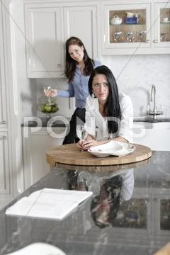 Two friends relaxing in the kitchen Stock Photos