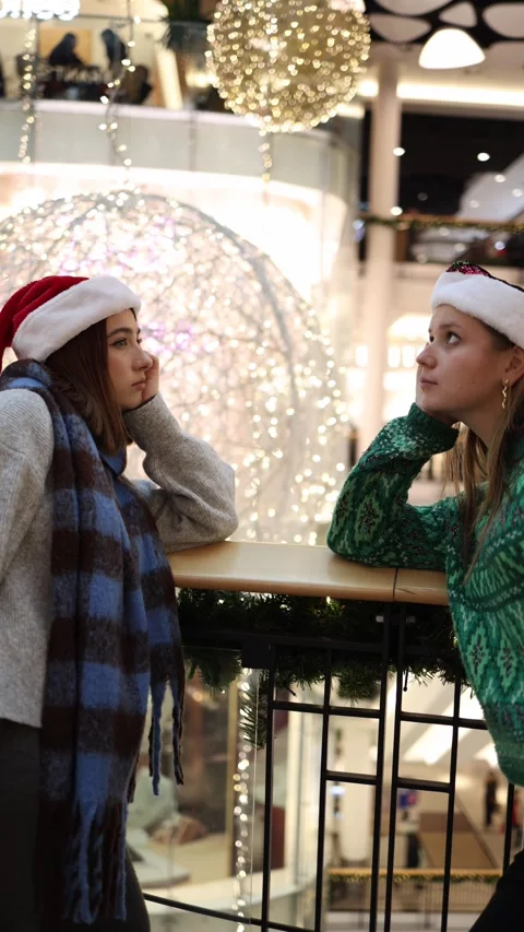 Two friends rest after long holiday shopping in a festive mall Stock Footage 324815029