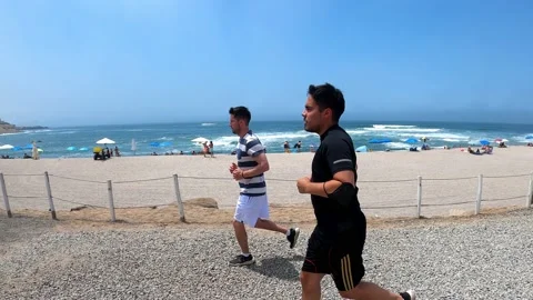 Two friends running on the beach in 4k Vidéo 195134354
