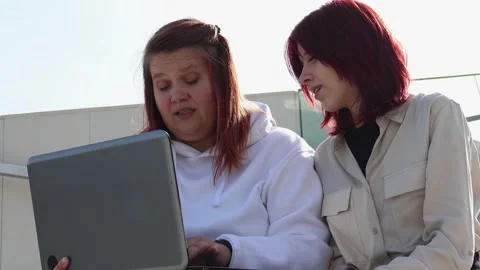 Two friends share laughter while exploring technology outdoors together Stock Footage 295274999