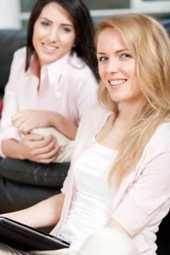 Two friends sharing a computer tablet and chatting Stockfoto's