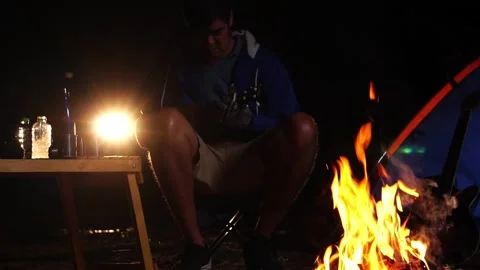 Two friends singing playing ukulele at forest night bonfire 库存影片 228447707