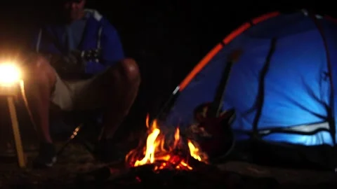 Two friends singing playing ukulele at forest night bonfire 库存影片 228447739