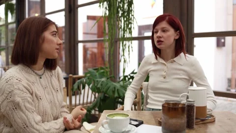 Two friends sit in a cafe one angrily confronting  Stock Footage 320827323