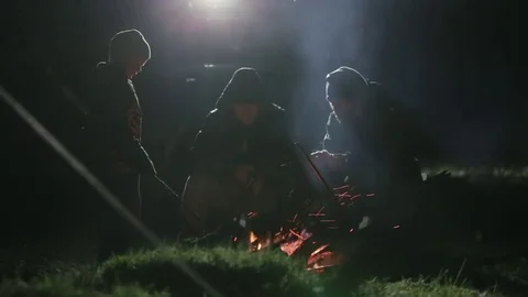 Two friends sitting at night next to bonfire fire and talking. Stock Footage 76603805