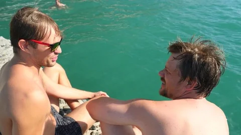 Two friends sitting together on the sea pier. 4k, slow motion Stock Footage 80739900