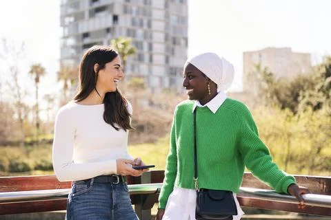 Two friends smiling happy while chatting carefree Stock Photos