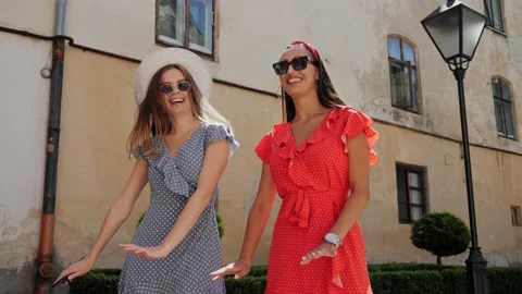 Two friends in a stylish look playfully dance and having fun in urban street. Video stock 138078038
