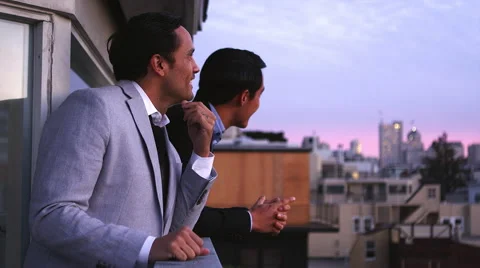 Two friends in suits hang out on a rooftop and take pictures at dusk Video stock 44190207