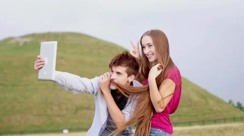 Two friends with tablet taking selfies.  Summer time. Stock Footage 53829955