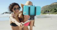 Two Friends Taking Selfies On The Beach Using Selfie Stick Stock Footage