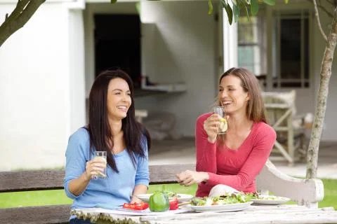 Two friends talking and having lunch together Stock Photos
