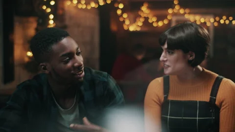 Two friends talking at the bar with beautiful lights in the back Video stock 132014791