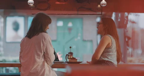 Two friends talking in a bar over tea and cake Stock Footage 203582036