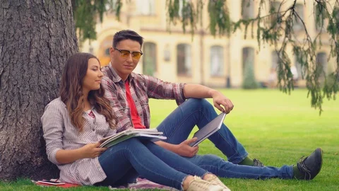 Two friends talking under tree. Video stock 127912570