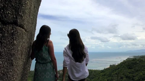 Two friends talking with a view of the sea in the background Stock Footage 83534759