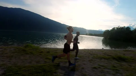 Two friends train by running by the lake. Stock Footage 133608829