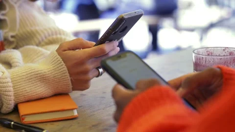 Two friends using mobile phone in a cafe Stock Footage 171991167