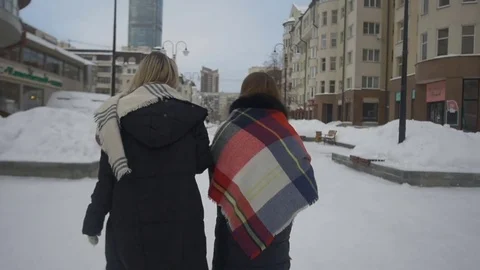 Two friends walking down the street and drink coffee in winter Видео 71155789