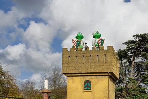 Two frog knight statues stand guard on top of a yellow castle tower in Duinre Stock Photos