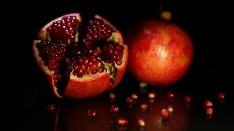Two fruit grenades lie on a black table on a black background. HD Stock Footage 89962256