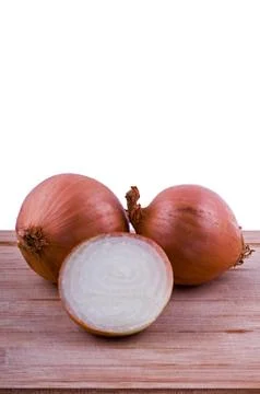 Two full and one half onion on chopping board closeup Stock Photos