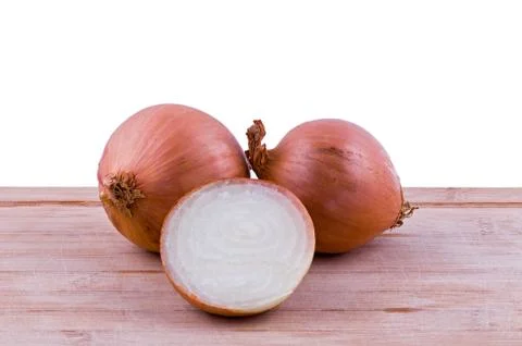 Two full and one half onion on chopping board Stock Photos