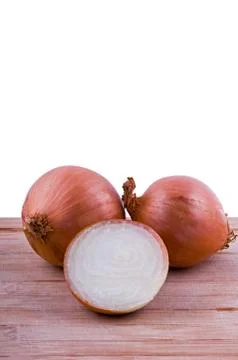 Two full and one half onion on chopping board vertical Stock Photos