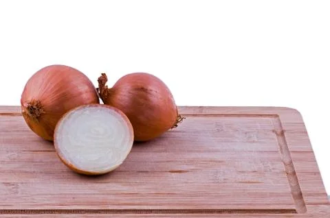Two full and one half onion on chopping board Stock Photos